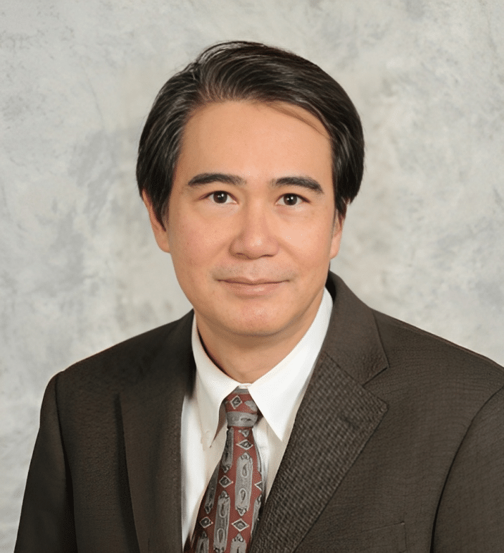 Portrait of Dr. Tien Nguyen, MD, FAAD, in a brown suit and tie
