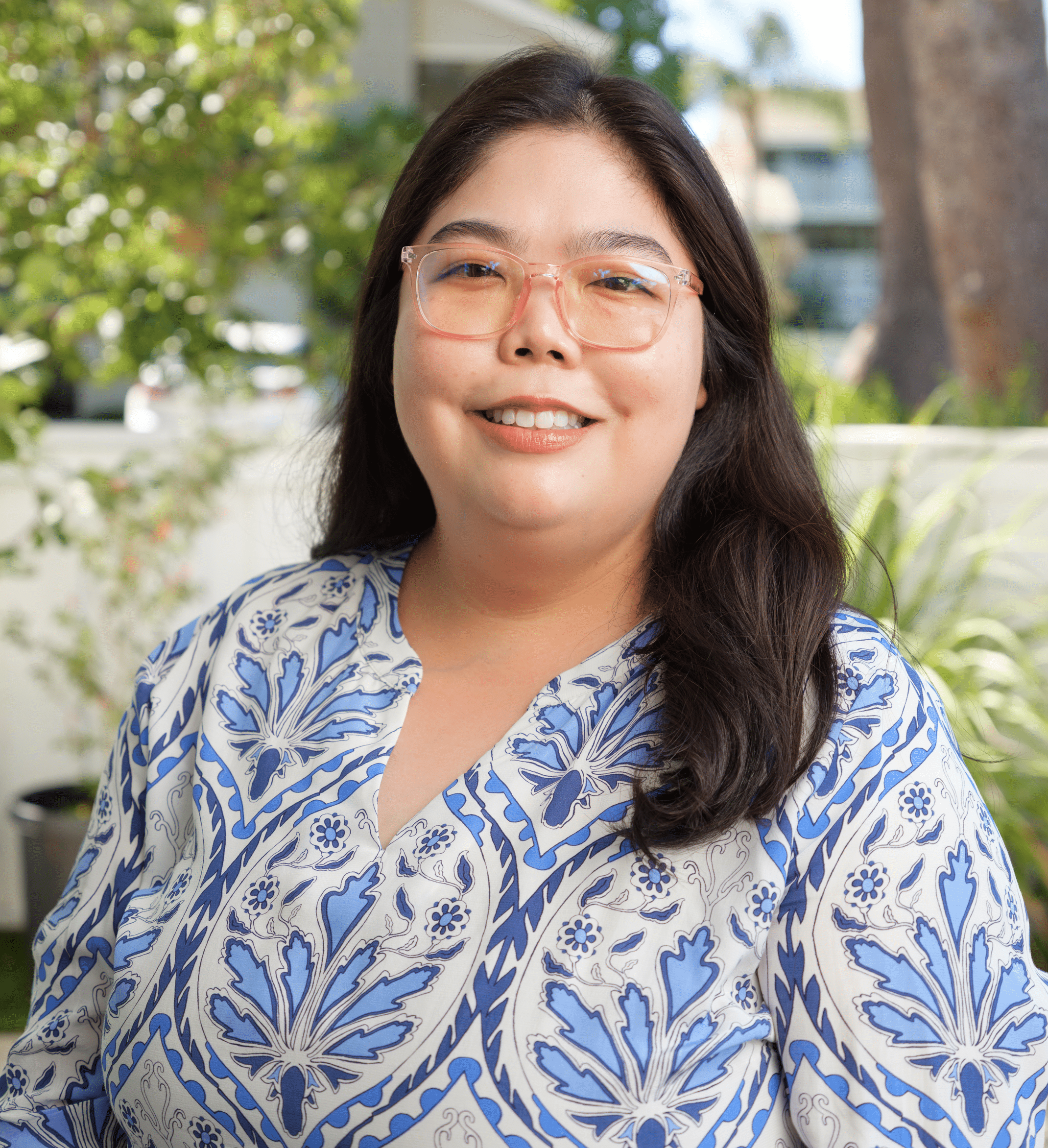 Portrait of Dr. Samantha Tran, MD, FAAD, smiling in a blue patterned top